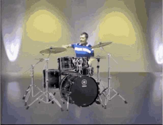 a man playing drums with a yamaha drum set in the background