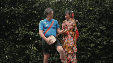 a man in a blue shirt and a woman in a kimono are playing musical instruments
