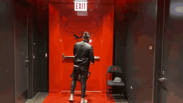 a man stands in front of an exit sign