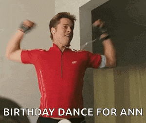 a man in a red shirt is dancing with his arms in the air while wearing headphones .