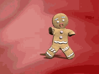 a gingerbread man is standing on a red surface