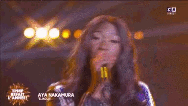 aya nakamura is standing on a stage in front of a crowd of people