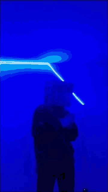 a person is standing in front of a blue light beam