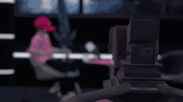 a person in a pink shirt is sitting in front of a video camera