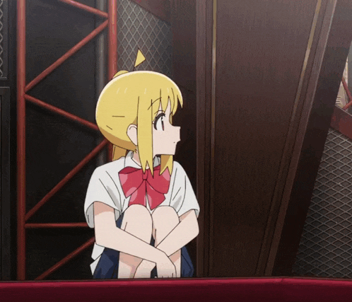 a girl with blonde hair and a red bow sits on a red couch