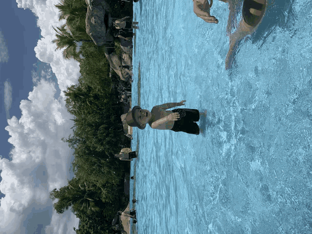 a boy in a hat is standing in a pool