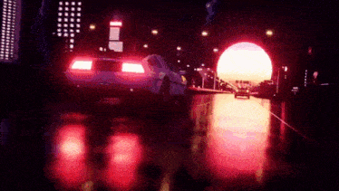 a car is driving through a tunnel at night with a red light coming out of it .
