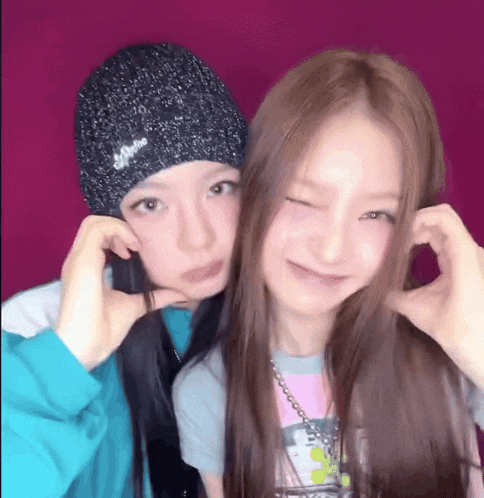 two girls are posing for a picture and one is wearing a hat that says supreme
