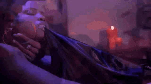 a woman is laying on a bed with her eyes closed in a room with candles .