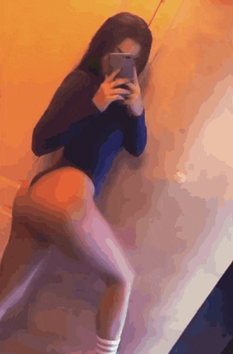 a woman taking a picture of herself in a mirror