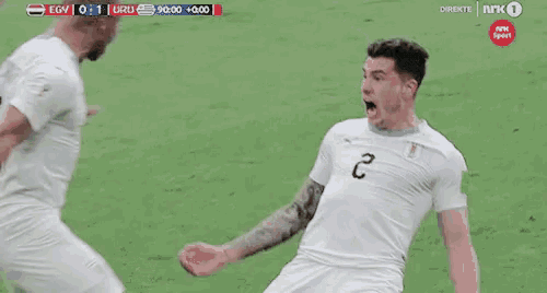 a soccer player with the number 2 on his shirt is being tackled by another player .