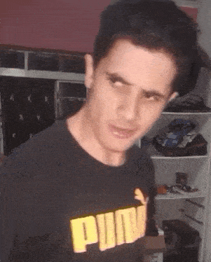 a man wearing a black puma shirt making a face