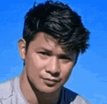 a close up of a man 's face with a blue sky behind him
