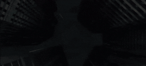a cartoon character is standing in the dark with a cape on .