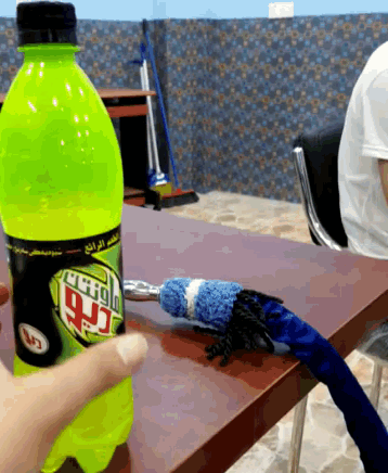 a person is holding a bottle of mountain dew next to a hookah