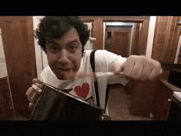 a man wearing a heart shaped shirt is holding a pot