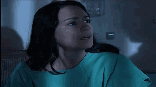 a woman in a hospital gown is looking up