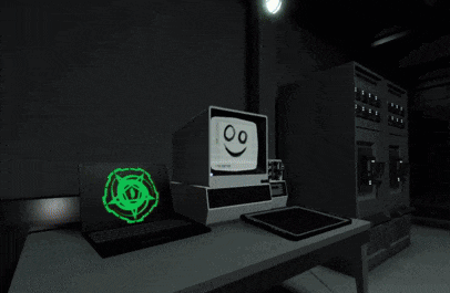 a computer with a smiley face on it sits on a table next to a laptop