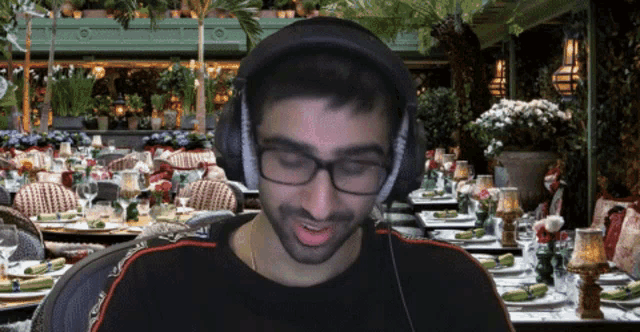 a man wearing headphones sitting in front of a restaurant