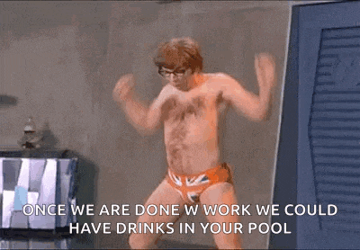 a shirtless man in a british flag swim trunks is dancing .