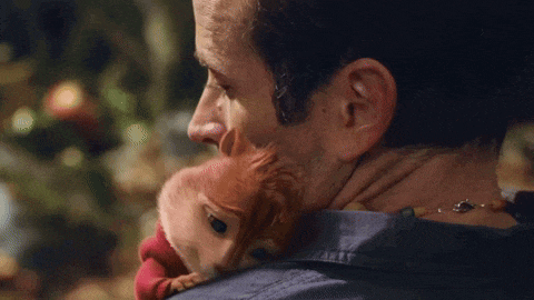 a man is holding a squirrel in his arms .