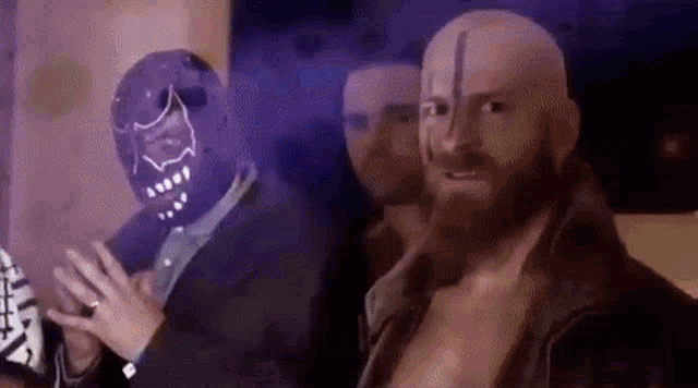 a man with a beard and a mask is standing next to another man with a beard .