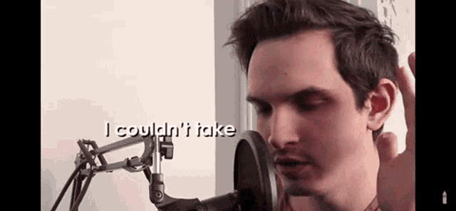 a man is singing into a microphone with the words `` i could n't take '' written on the screen .