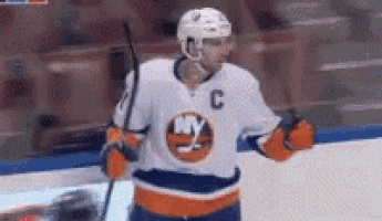 a hockey player wearing a jersey with the letter c on it is standing on the ice holding a stick .