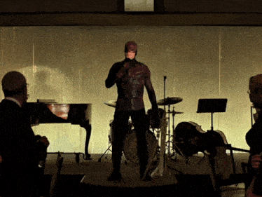 a man in a daredevil costume is standing on a stage with a microphone