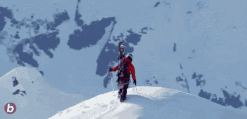 a snowboarder is standing on top of a snowy mountain