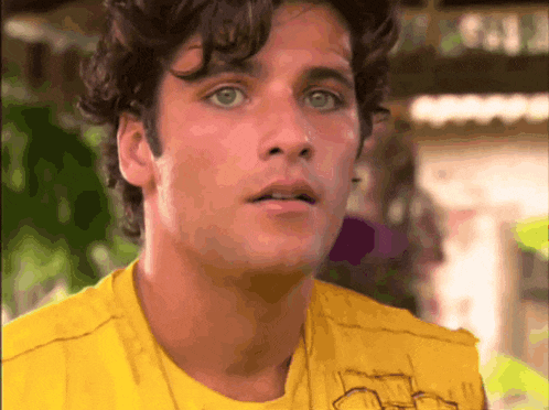 a close up of a man 's face wearing a yellow shirt that says california