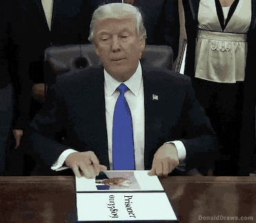 donald trump is sitting at a desk with a picture of him on it