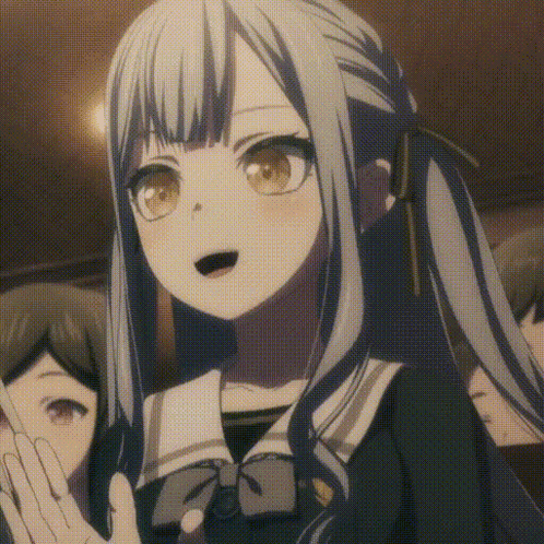 a girl with gray hair and brown eyes is standing in front of a crowd of people .