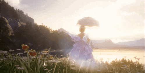 a woman in a pink dress holds an umbrella in a field