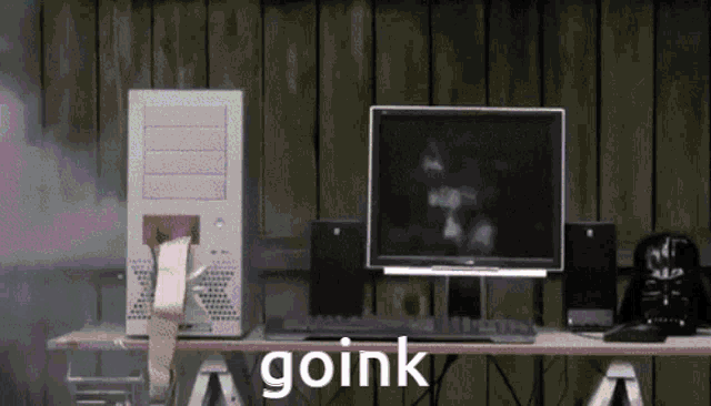 a computer is sitting on a desk and the word goink is on the table