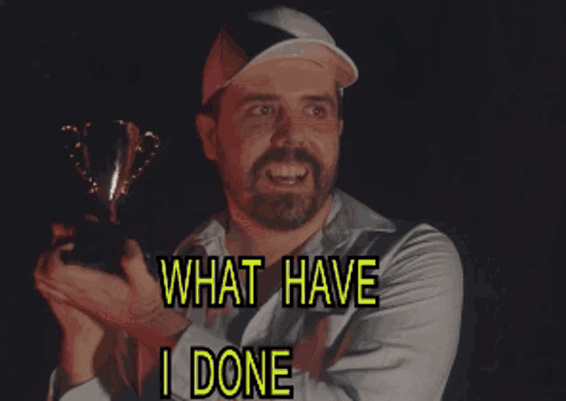 a man holding a trophy with the words what have i done behind him