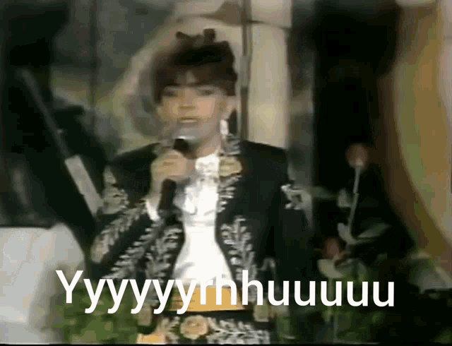 a man singing into a microphone with the words " yyyyyrnhuuuu " written below him