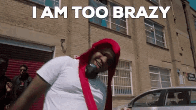 a man in a red hood says i am too brazy in front of a building