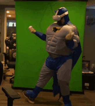 a man dressed in a batman costume is dancing in front of a green screen