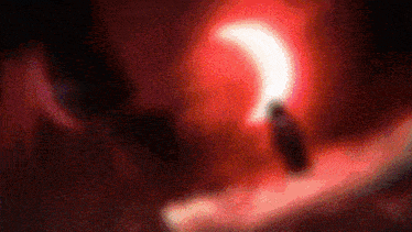 a candle is lit up in the dark with a crescent moon in the background