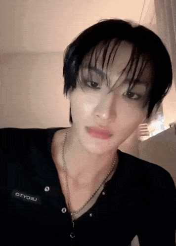 a close up of a person 's face with wet hair and a necklace .