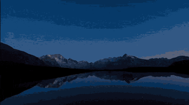 the milky way is visible in the night sky above a lake