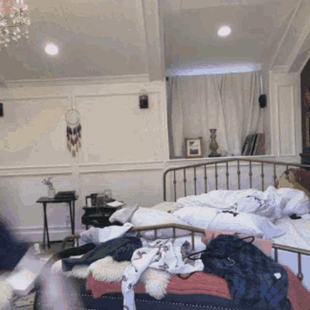 a bedroom with a messy bed and a dream catcher hanging on the wall