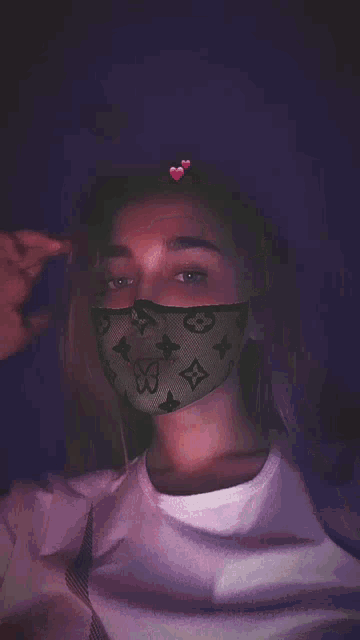a woman wearing a louis vuitton face mask
