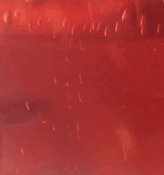a blurred image of a red background with a few lights in the background