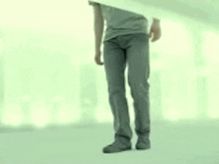 a man is standing in a hallway with his head visible through a hole in the wall .
