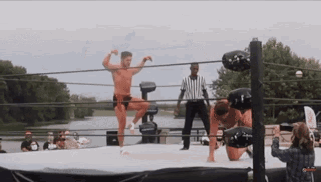 a man is standing in a wrestling ring with a referee