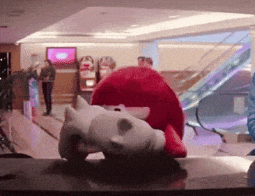 a stuffed animal is laying on a table in a room with an escalator in the background