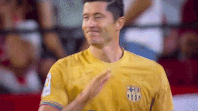 a man in a yellow shirt is clapping his hands