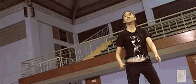 a woman wearing a black shirt with a picture of a man on it